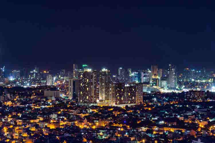 Stunning city skyline illuminated at night with dazzling skyscrapers, vibrant streets, colorful lights, bustling atmosphere, and unforgettable urban scenery.