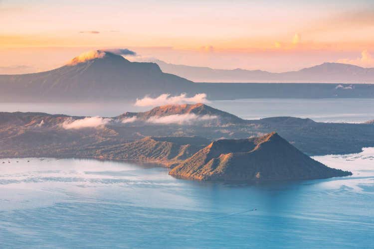 Majestic volcano surrounded by lush landscapes, serene lake views, dramatic peaks, natural beauty, scenic surroundings, and breathtaking panoramic vistas together.